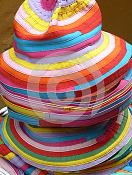 A stack of colorful summer hats at a street market stall in Brescia photo