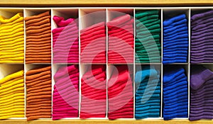 Stack of Colorful Horizontal Various Fluffy Bathing Towels in Wooden Shelf for Shopping Showcase