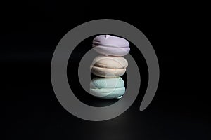 A stack of colorful marshmallows on a black background