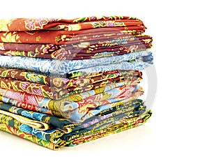 Stack of colorful native thai fabric sarong isolated on white background