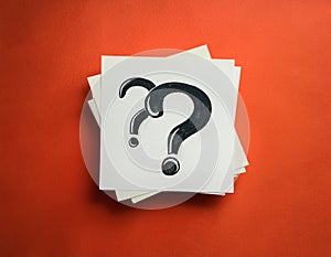 Paper notes with question marks on Coral background, flat lay. Space for text
