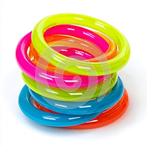 Stack of colorful plastic bangles on a white surface studio