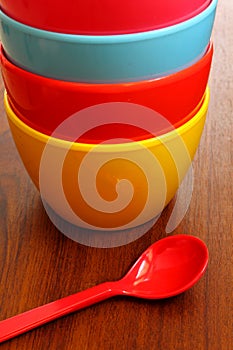 Stack of colorful plastic bowl with blue spoon