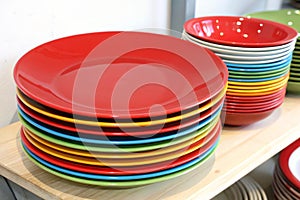 Stack of colorful plates with empty red one