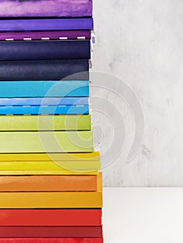 Stack of colorful rainbow books on white background. Copy space