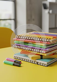 Stack of Colorful Spiral Notebooks and Pencils on Yellow Desk