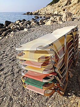 Stack colorful sunbeds on a sandy beach in summer