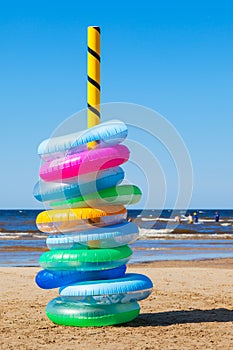 Stack of colorful swimming rings on sea beach