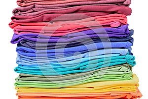 Stack of colorful t-shirt texture, isolated on white background. File contains a path to isolation.