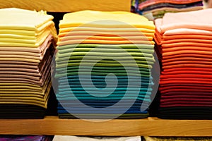 Stack of colorful t-shirts. Layers of colorful fabric. Stack of colorful folded clothes, multicolored background