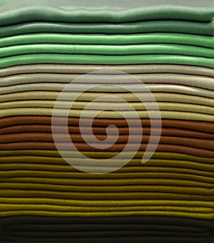 Stack of colorful t-shirts. Layers of colorful fabric. Stack of colorful folded clothes, multicolored background