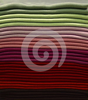 Stack of colorful t-shirts. Layers of colorful fabric. Stack of colorful folded clothes, multicolored background