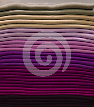 Stack of colorful t-shirts. Layers of colorful fabric. Stack of colorful folded clothes, multicolored background