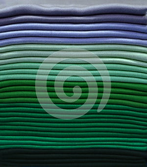 Stack of colorful t-shirts. Layers of colorful fabric. Stack of colorful folded clothes, multicolored background