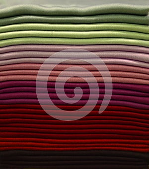 Stack of colorful t-shirts. Layers of colorful fabric. Stack of colorful folded clothes, multicolored background