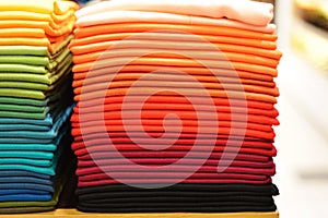 Stack of colorful t-shirts. Layers of colorful fabric. Stack of colorful folded clothes, multicolored background