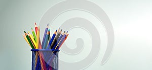 Stack of colorful textbooks and a glass of bright pencils on a white background, Concept of education, training, School tools,