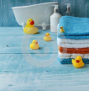 Stack of colorful towels and bath duck on the table