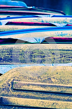 A stack of colorful, weathered upturned boats