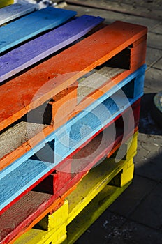 Stack of colorful wooden pallets outside