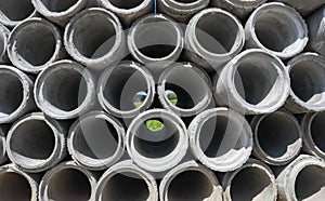 Stack of concrete drainage pipes for wells and water discharges with blue sky