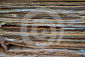 stack of containerboard sheets or old brown box paper recycle in warehouse facility