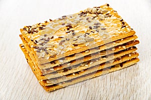 Stack of cookies with sunflower seeds, flaxseeds and sesame on table