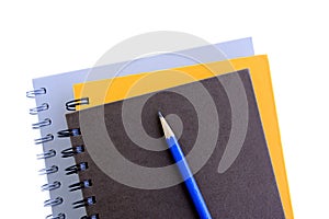 Stack of copybooks with pencil on top