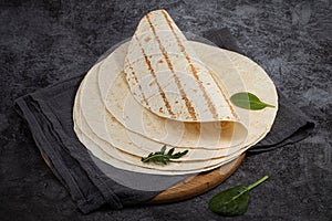 Stack of corn tortillas on dark background. Mexican food