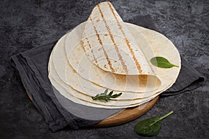 Stack of corn tortillas on dark background. Mexican food