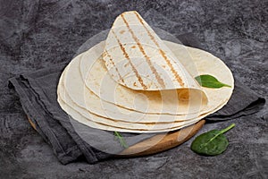 Stack of corn tortillas on dark background. Mexican food