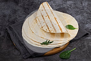 Stack of corn tortillas on dark background. Mexican food