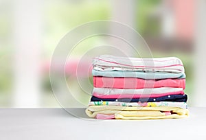 Stack cotton clothes on table empty space background.