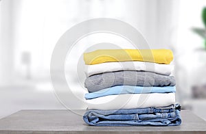 Stack of cotton colorful clothes on table indoors.Stacked apparel.Folded clean clothing