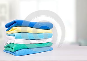 Stack of cotton colorful folded clothes on table empty space