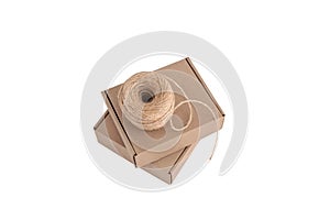 Stack of craft paper boxes and coil of rope isolated on white