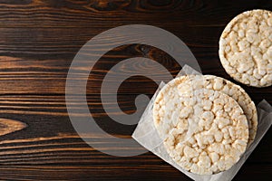 Stack of crunchy rice cakes on wooden table, flat lay. Space for text
