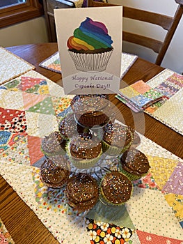 A stack of cupcakes with chocolate frosting on display for national cupcake day