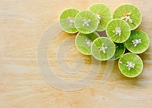 Stack of cutting fresh lemon lime fruits on wooden chopping board background