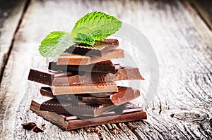 Stack of dark and milk chocolate pieces with mint leaf