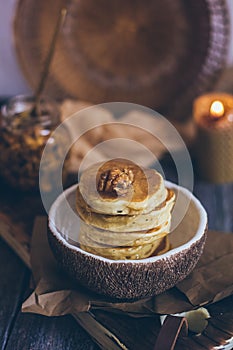 Stack of delicious pancakes with honey, nuts on wooden background