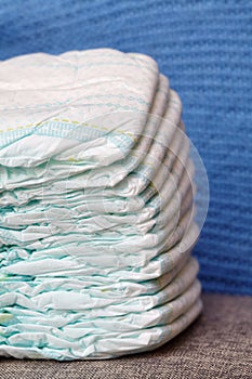 Stack of diapers or nappies on blue knitted background