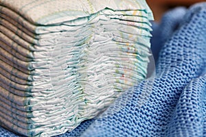 Stack of diapers or nappies on knitted blanket