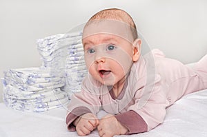 Stack of diapers or nappies with newborn baby photo