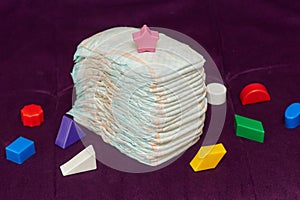 Stack of diapers or nappies on purple background