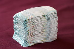 Stack of diapers or nappies on purple background