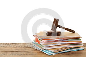 Stack of different files with documents and gavel on wooden table against white background. Space for text