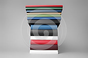 Stack of different hardcover books on light grey background