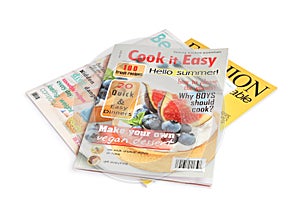 Stack of different magazines on white