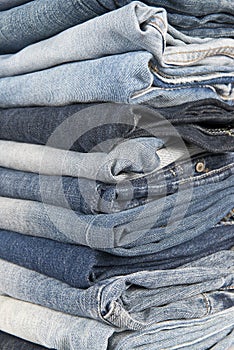 Stack of different old worn blue jeans
